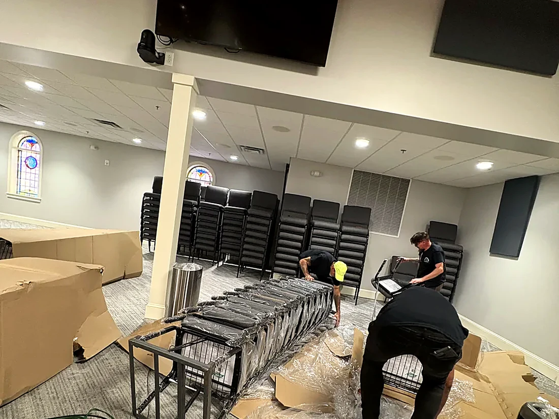 Commercial move: chairs and event furniture staged and wrapped in a Greenville venue